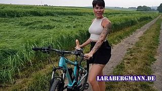 Коротко стриженая женщина катается на велосипеде и трахает себя дилдо